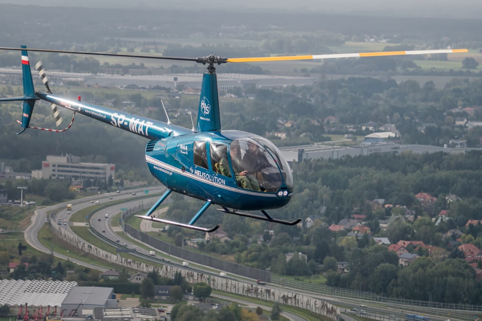 Robinson R44 von Heli Solution im Flug über der Stadt